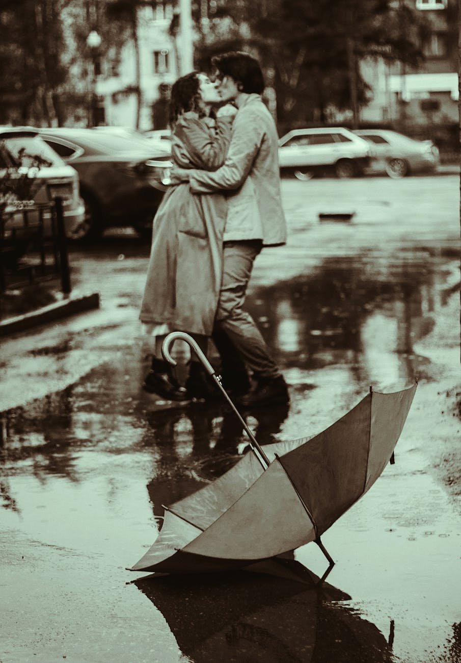 a romantic couple kissing in the rain