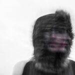 Creepy blurred photo of a person's face and a furry hood