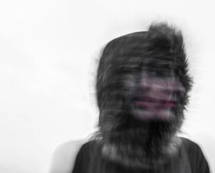 Creepy blurred photo of a person's face and a furry hood